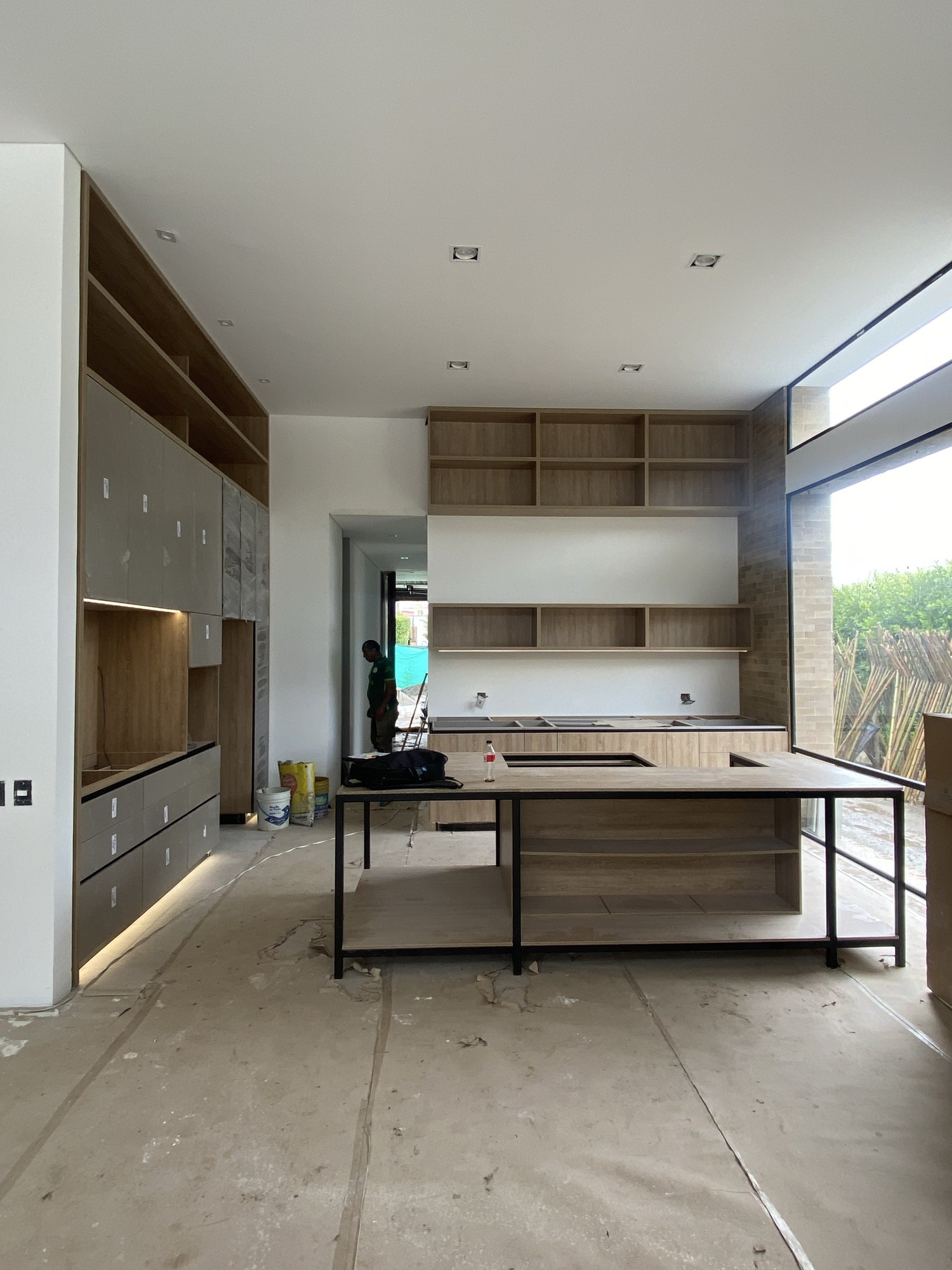 Cocina moderna con isla central, conexión visual al exterior y diseño integrado de espacios