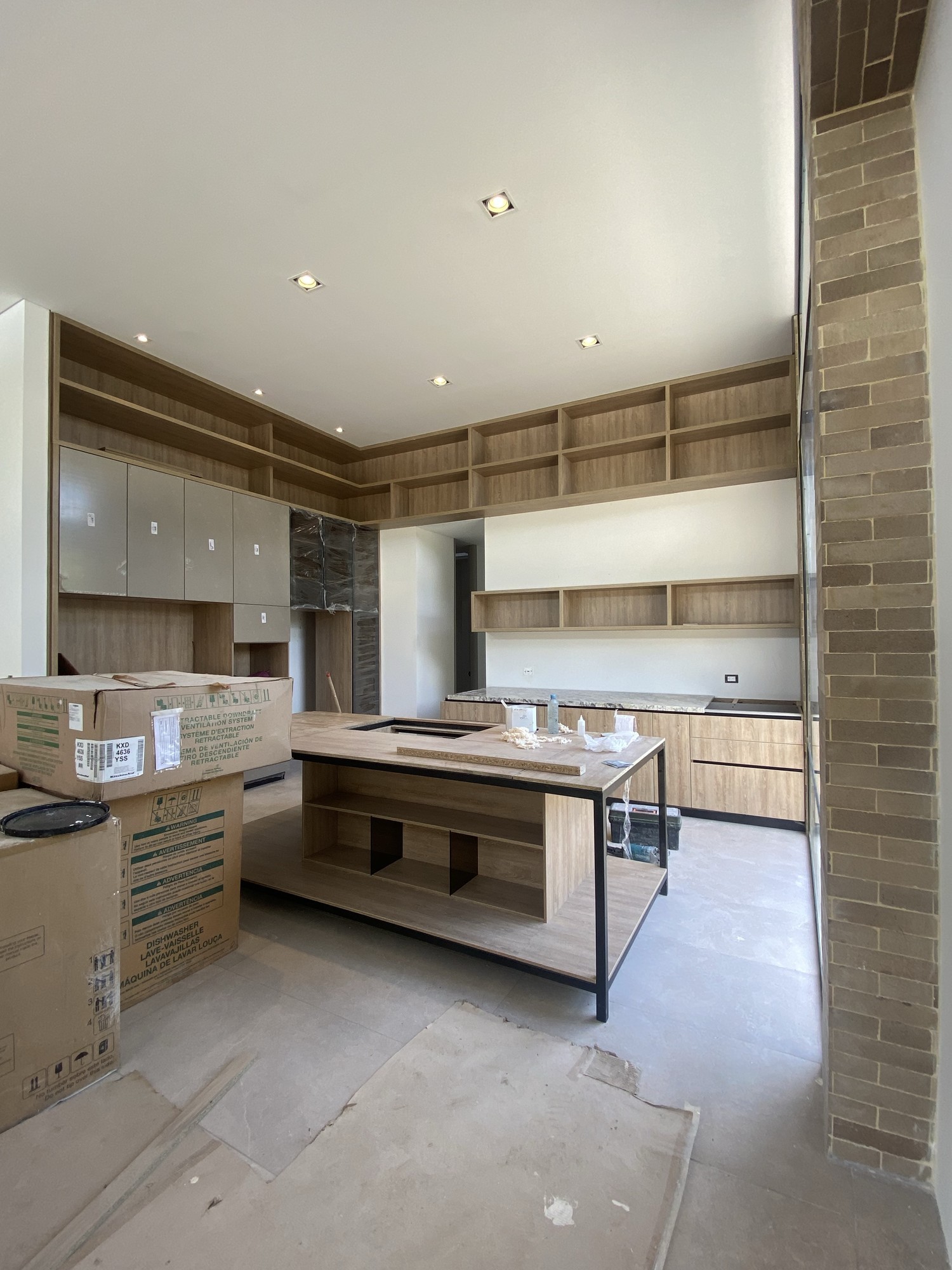 Cocina moderna con isla central, circulación fluida y mobiliario en madera diseñado a medida