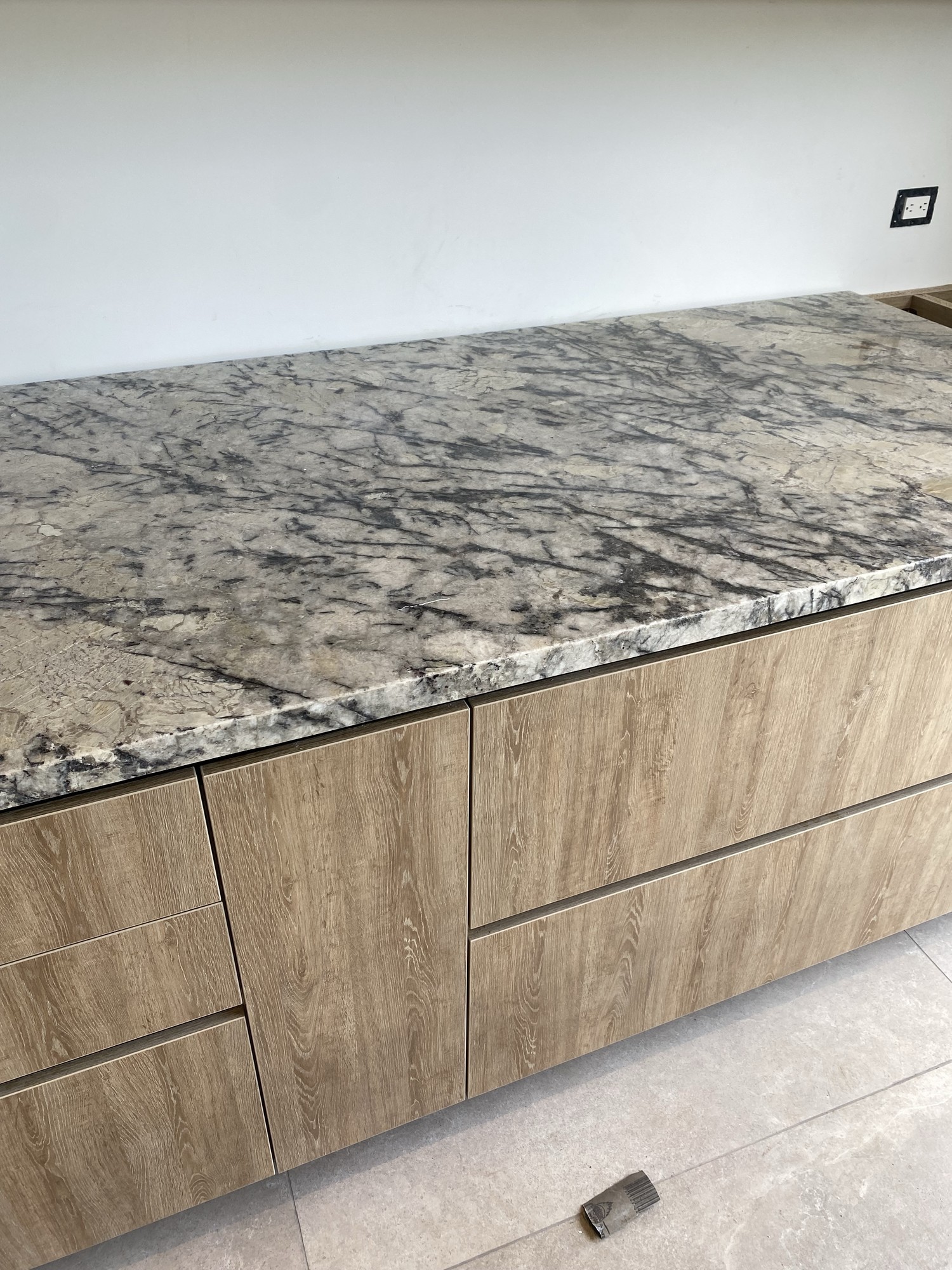 Detalle de cubierta en piedra y mobiliario en madera con unión precisa en diseño de cocina moderna